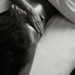 a person laying on a bed with their hands on their back
