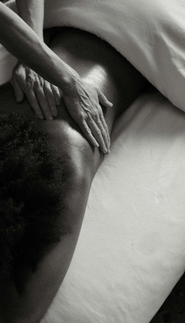 a person laying on a bed with their hands on their back